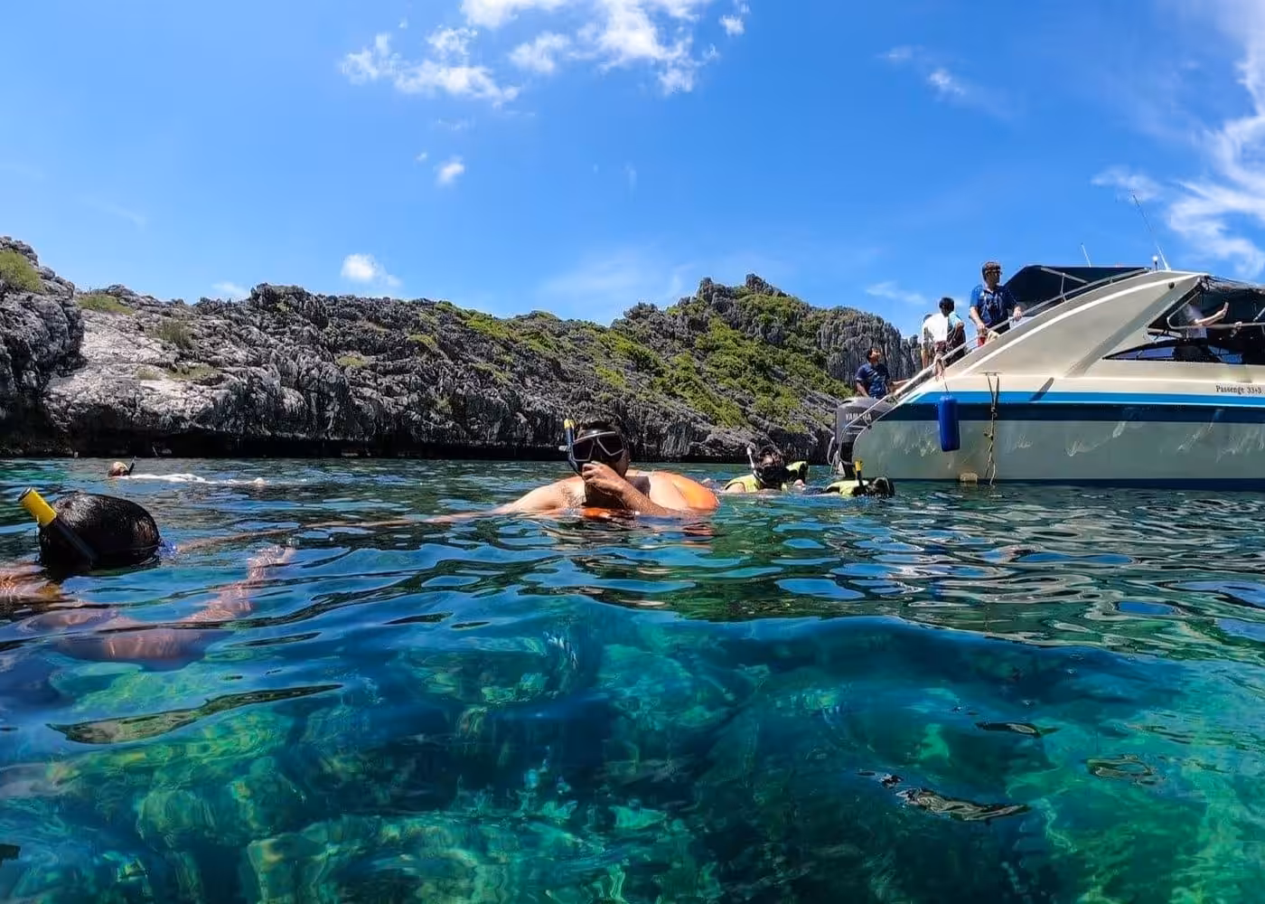 Snorkeling tour with speedboat at limestone cliffs in crystal clear turquoise waters, Thailand